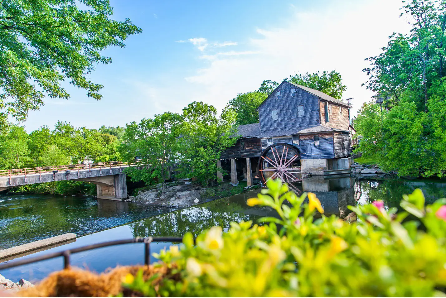 Historic Old Mill in Pigeon Forge, Tennessee, surrounded by lush greenery and a peaceful river.