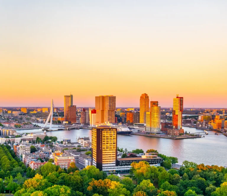 Cruise Travel 29 Holland America Line cruise ship docked in Rotterdam with city skyline at sunset