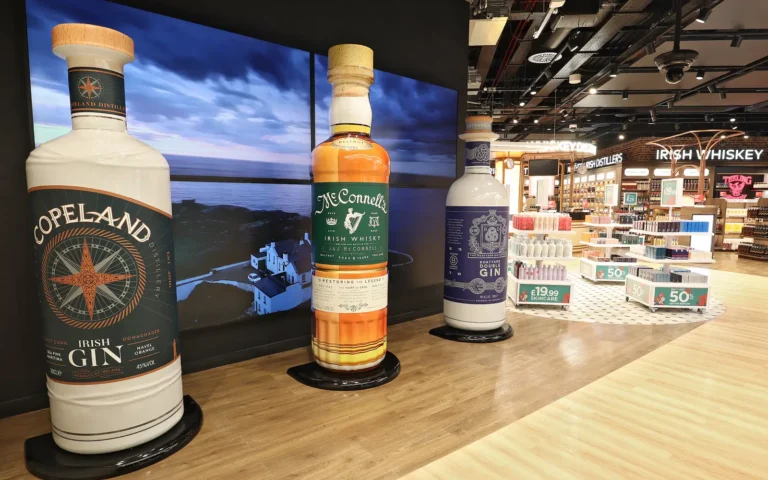 Large promotional bottles of Irish gin and whiskey displayed at Belfast Airport’s new Aelia Duty Free store.