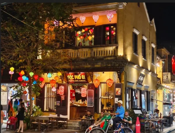Trips 49 Shophouse in Hoi An Old Town illuminated with colorful lanterns at night, with a trishaw passing by