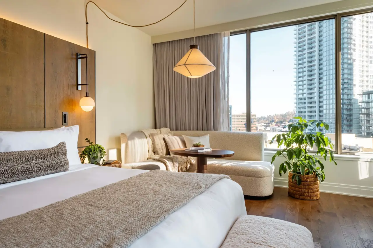 Seattle’s 1 Hotel Is Now Open 3 Studio Suite at 1 Hotel Seattle featuring natural materials, cozy textures, and city skyline views through large windows.