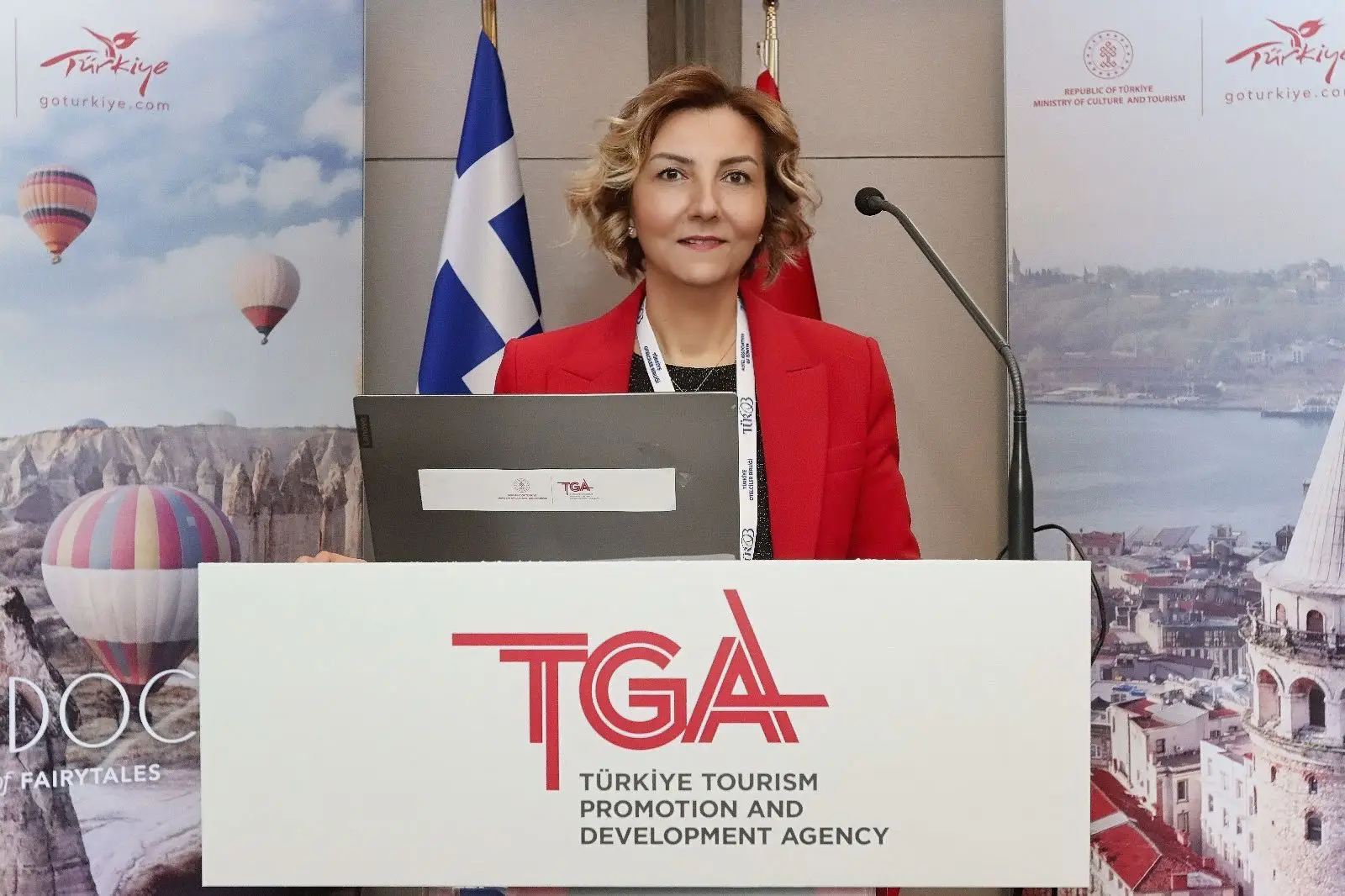 1.4 Million Turks Expected To Visit Greece In 2025 4 TÜROB President Müberra Eresin speaking at the Türkiye-Greece tourism workshop in front of TGA and GoTürkiye banners.