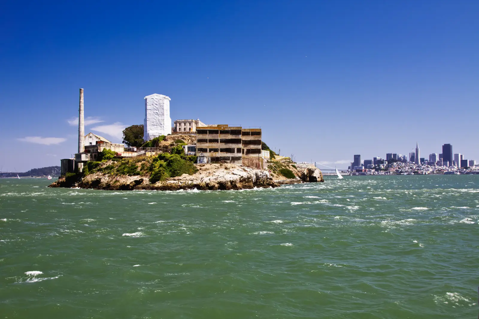 Alcatraz Island and San Francisco skyline seen across choppy waters under a clear blue sky