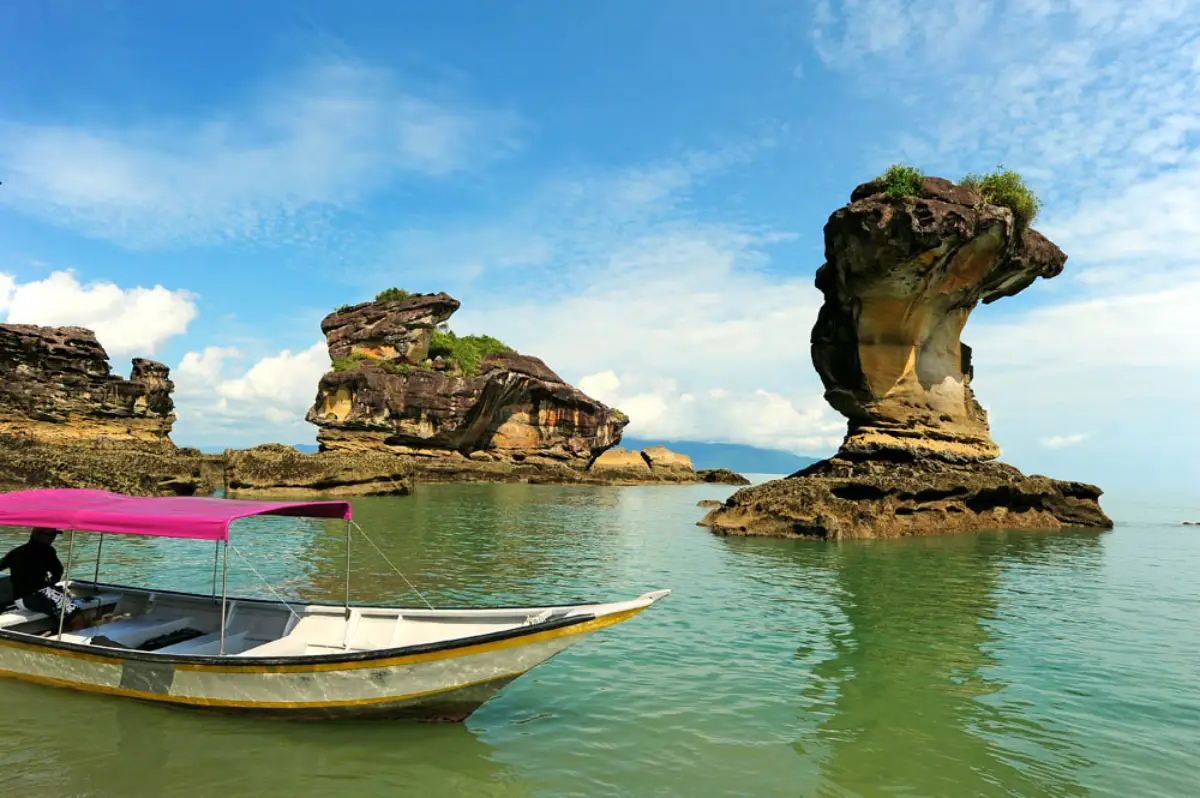 Awe-Inspiring Natural Wonders Of East Malaysia 8 Boat near iconic sea stacks at Bako National Park in Sarawak, Malaysia