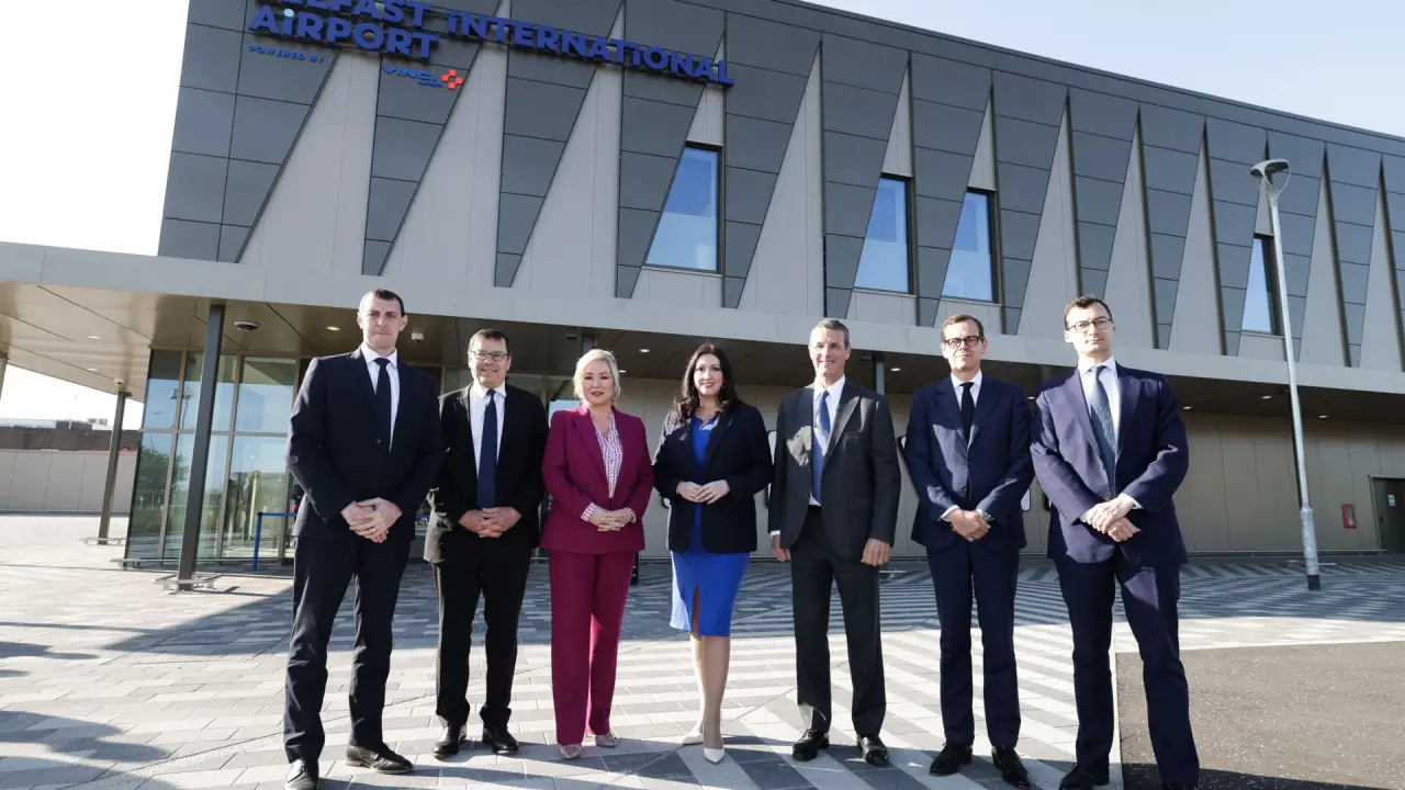 Executives and officials stand in front of Belfast International Airport’s new terminal extension during the official opening.