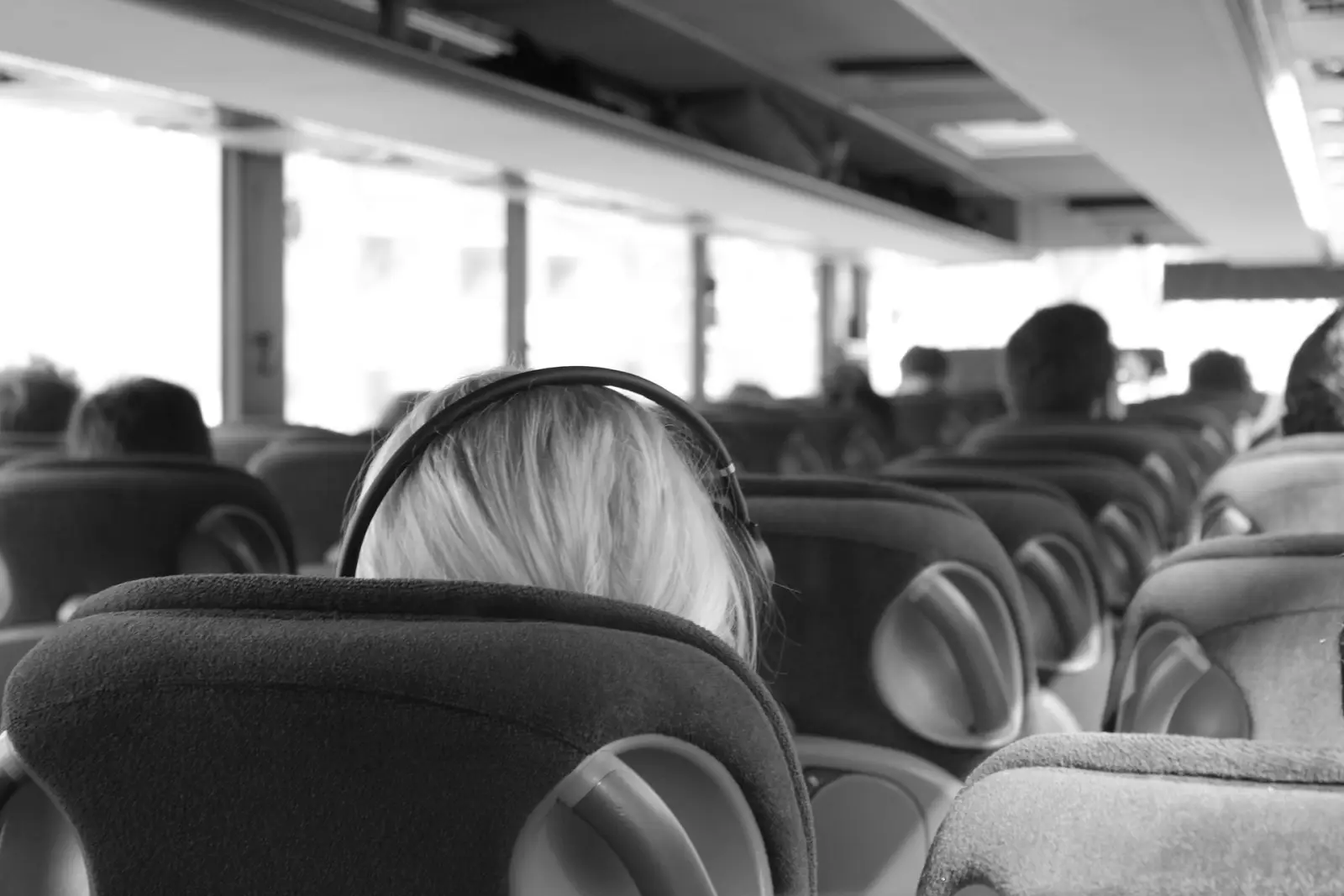 How To Entertain Yourself During A Long Road Trip 2 Passenger wearing headphones on a bus during a long journey