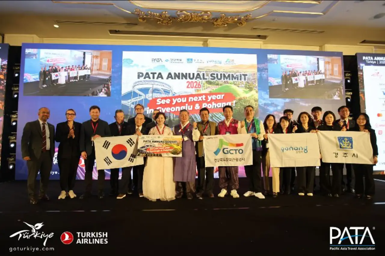 PATA and Korean delegation pose together holding flags during the official handover ceremony for the PATA Annual Summit 2026 in Gyeongju and Pohang.