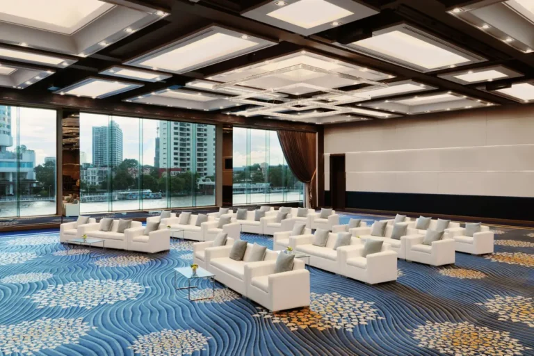 Modern riverside meeting room at Royal Orchid Sheraton Bangkok with white sofas and floor-to-ceiling windows overlooking the Chao Phraya River