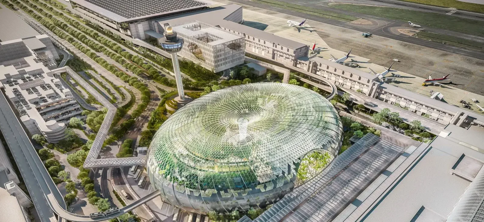 Aerial view of Singapore Changi Airport featuring the Jewel dome, control tower, terminals, and aircraft on the tarmac.