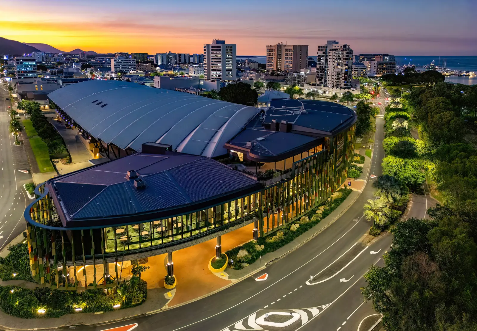 Aerial night view of the Cairns Convention Centre with city lights and waterfront in the background