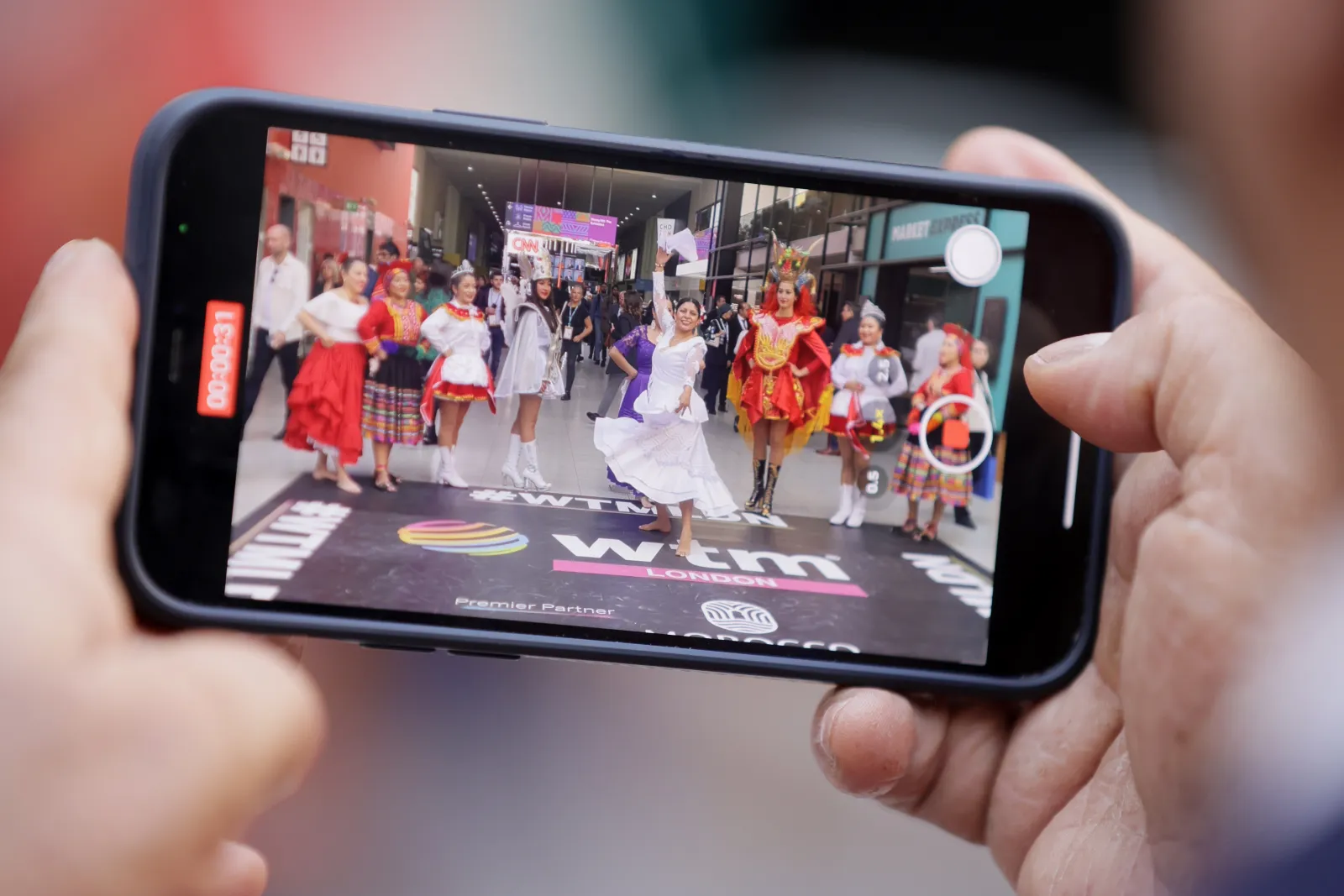 WTM London 2025 cultural dancers filmed on smartphone at event entrance