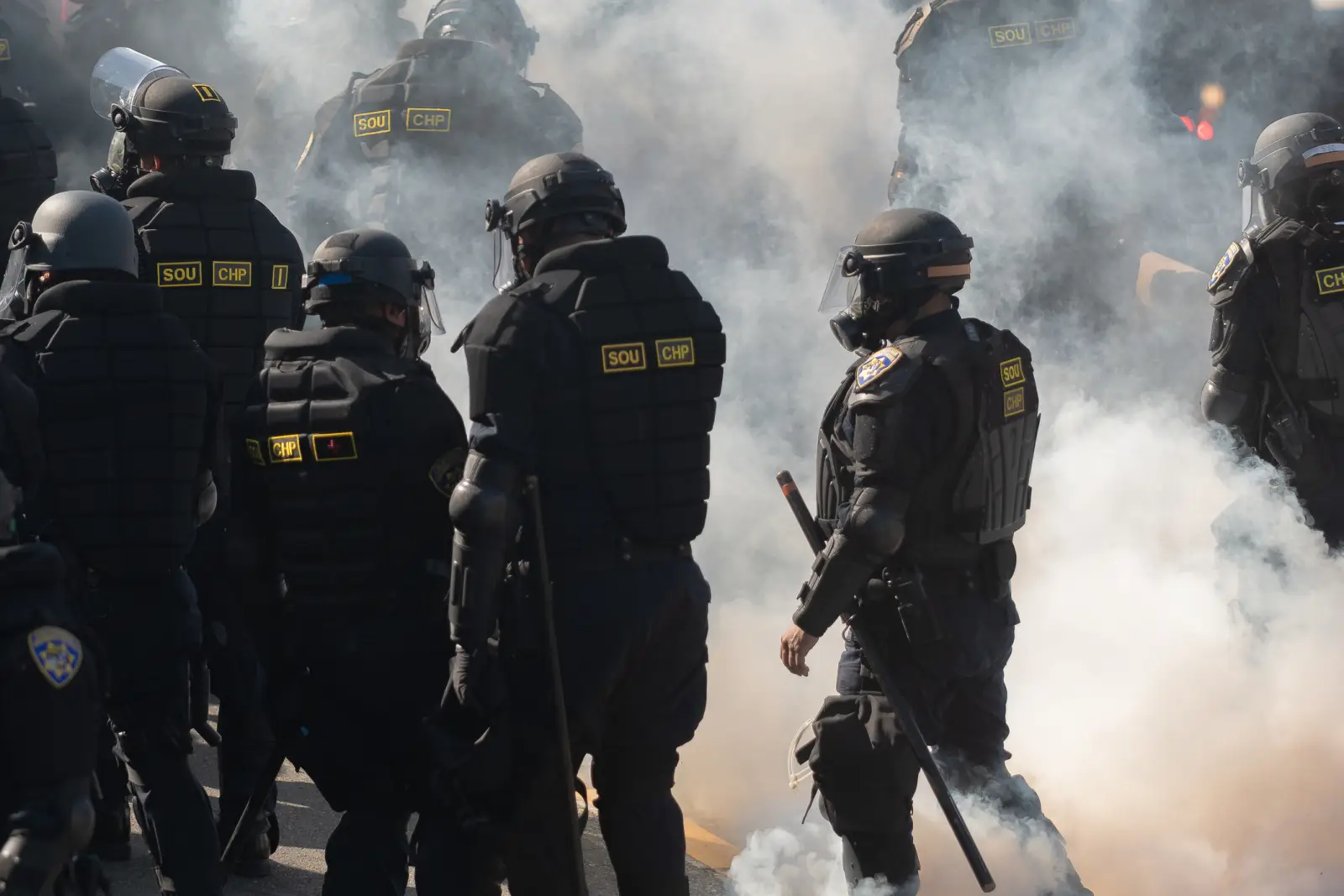 Riot police in protective gear during Los Angeles protests amid heavy smoke