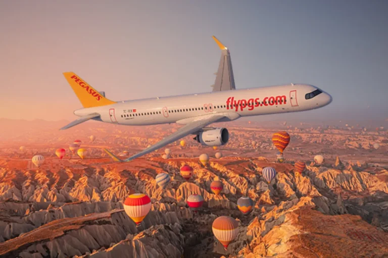 Pegasus Airlines Airbus A321neo flying over Cappadocia with hot air balloons at sunrise