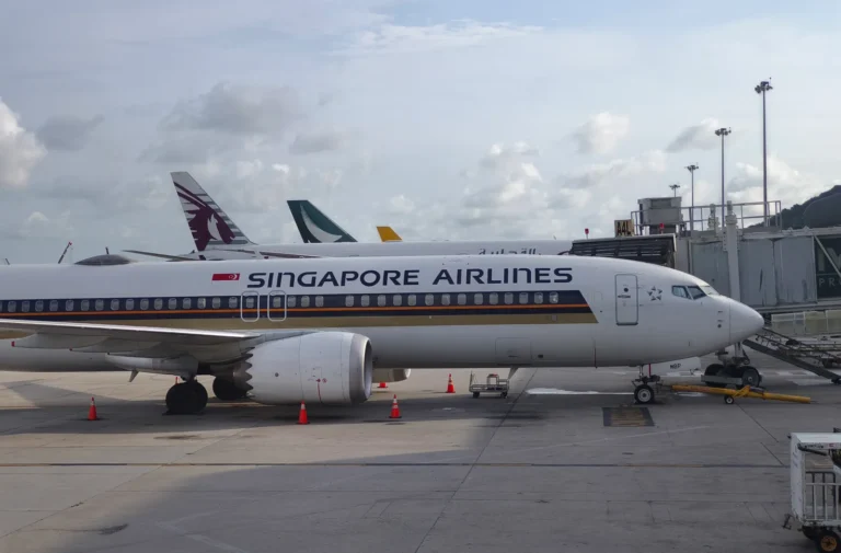 Singapore Airlines aircraft parked at airport gate with jet bridge connected