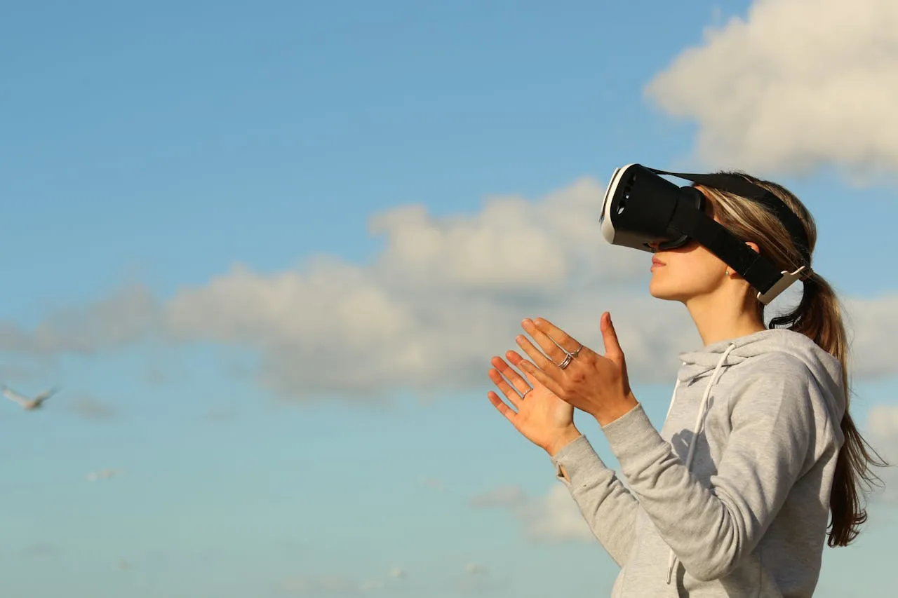 The Rise And Fall Of Location-Based Vr 3 Woman wearing a VR headset outdoors under a blue sky with scattered clouds