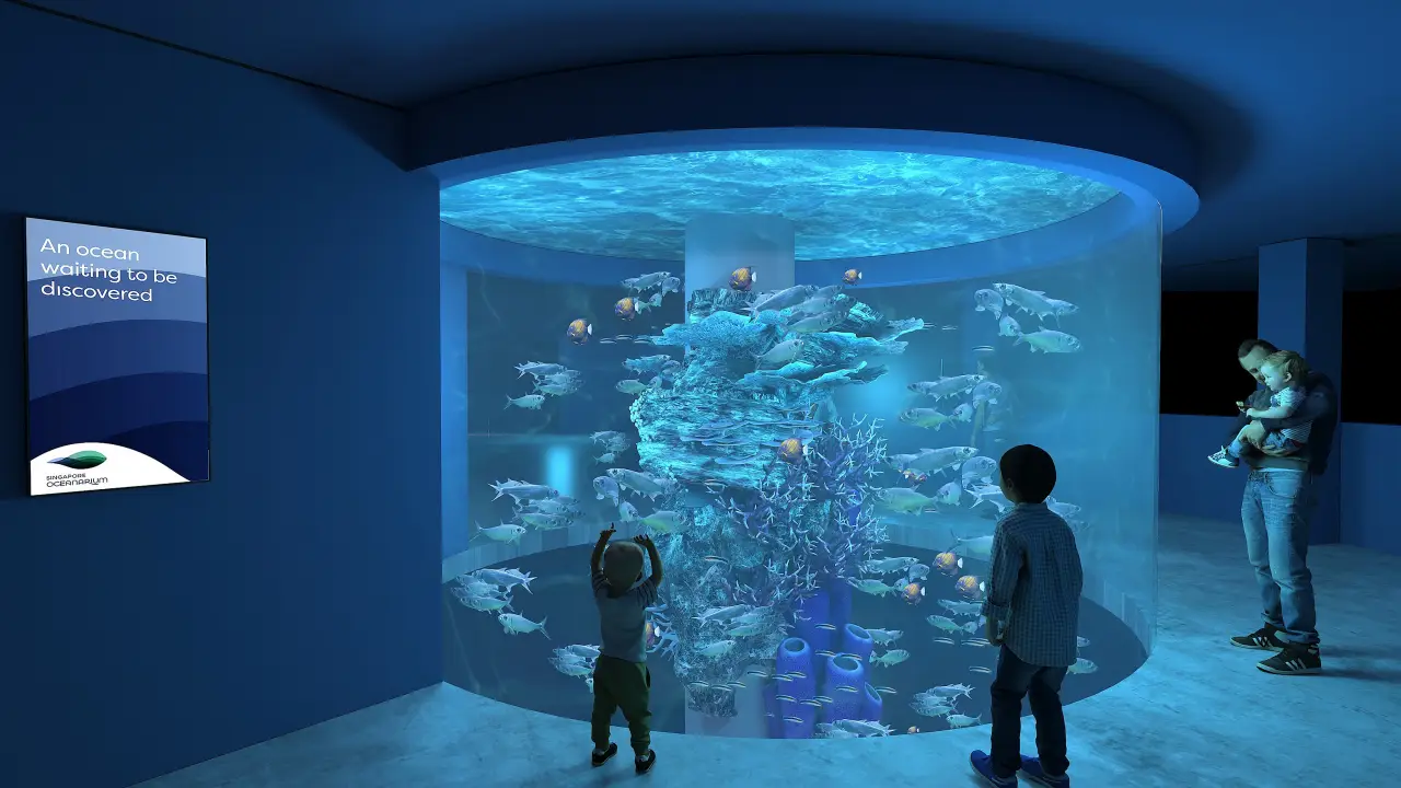 The New Singapore Oceanarium Opens, Connects Visitors To Marina Conservation 5 Children and a parent observe vibrant marine life swimming around a cylindrical aquarium in the Vertical Migrators zone at the Singapore Oceanarium.