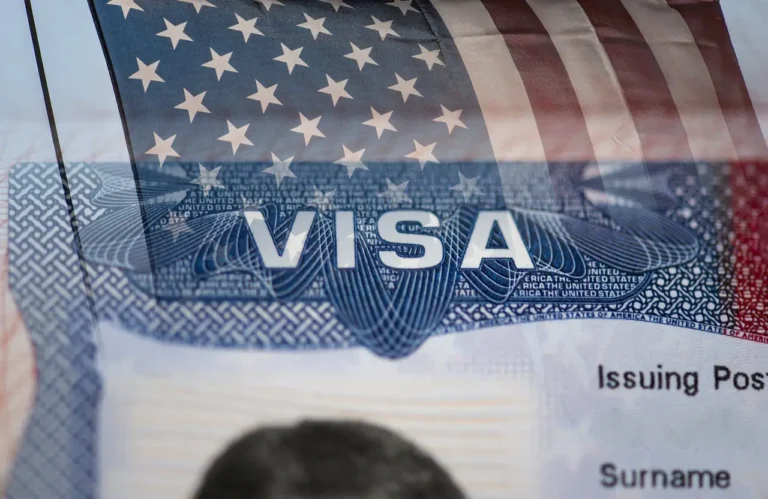 Tours 13 Close-up of a U.S. visa document overlaid with the American flag, symbolizing new travel regulations and visa fee changes.