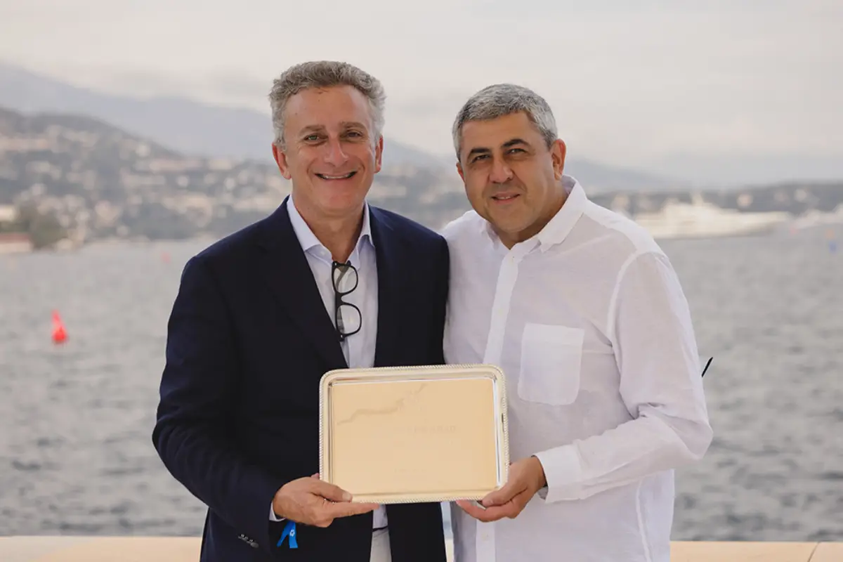 Alejandro Agag and Zurab Pololikashvili holding a plaque by the sea in Monaco.