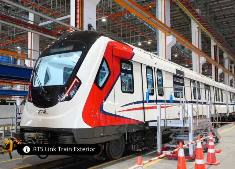 RTS Link train exterior view inside maintenance facility with red and blue livery