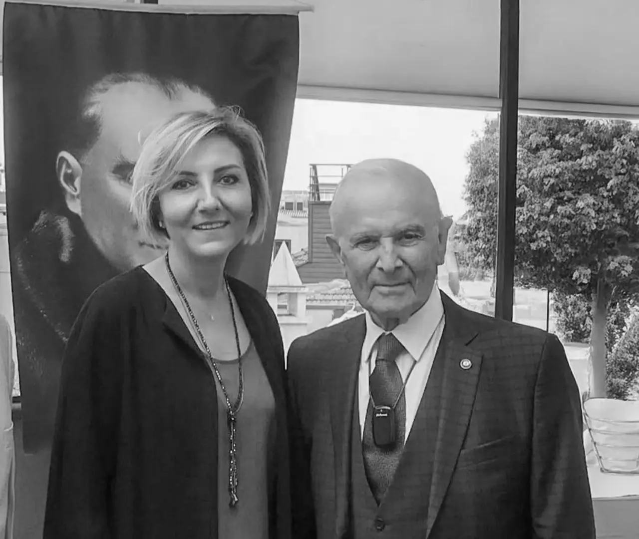 Müberra Eresin, President of the Turkish Hotel Association, poses with veteran hotelier and former TÜROB chair Sinan Babila at an event, with a portrait of Mustafa Kemal Atatürk visible in the background.