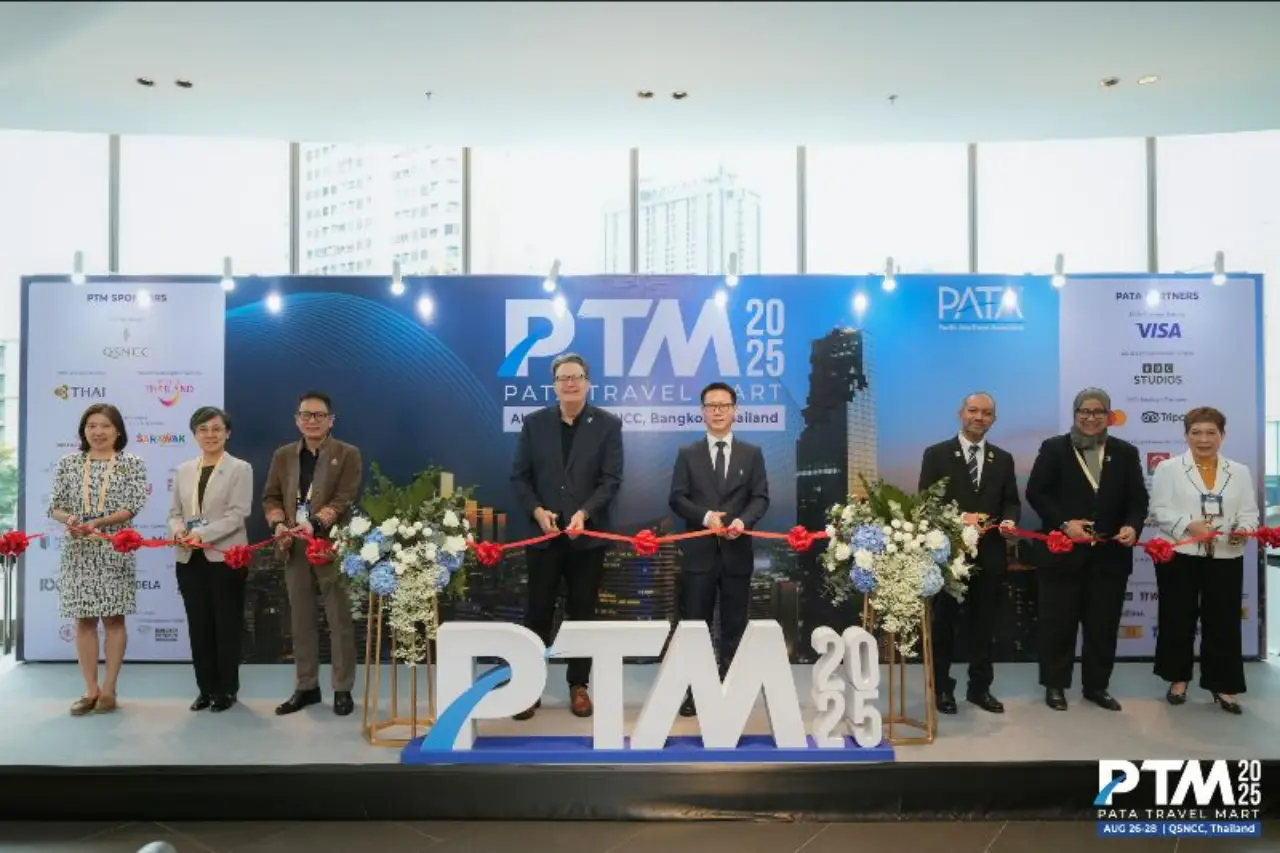 A group of officials and tourism leaders cut a red ribbon at the opening ceremony of the PATA Travel Mart 2025 in Bangkok, Thailand, standing in front of a stage backdrop with the PTM 2025 logo.
