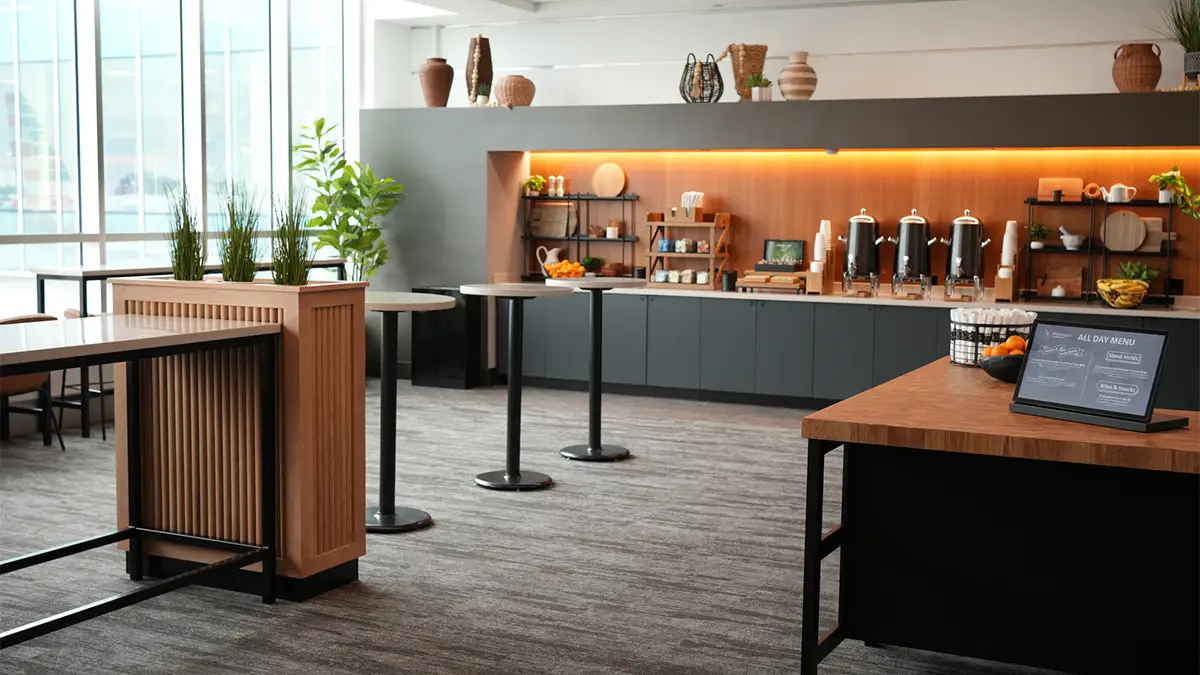 Interior of the new Provisions by Admirals Club lounge at Charlotte Douglas International Airport, featuring grab-and-go food counters, tall tables, and modern decor.