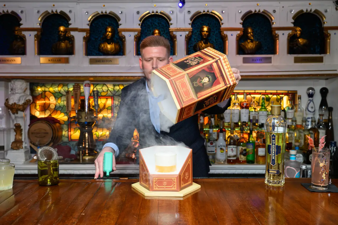Spellbound speakeasy bartender preparing a theatrical cocktail at the Cardini Bar aboard Star Princess
