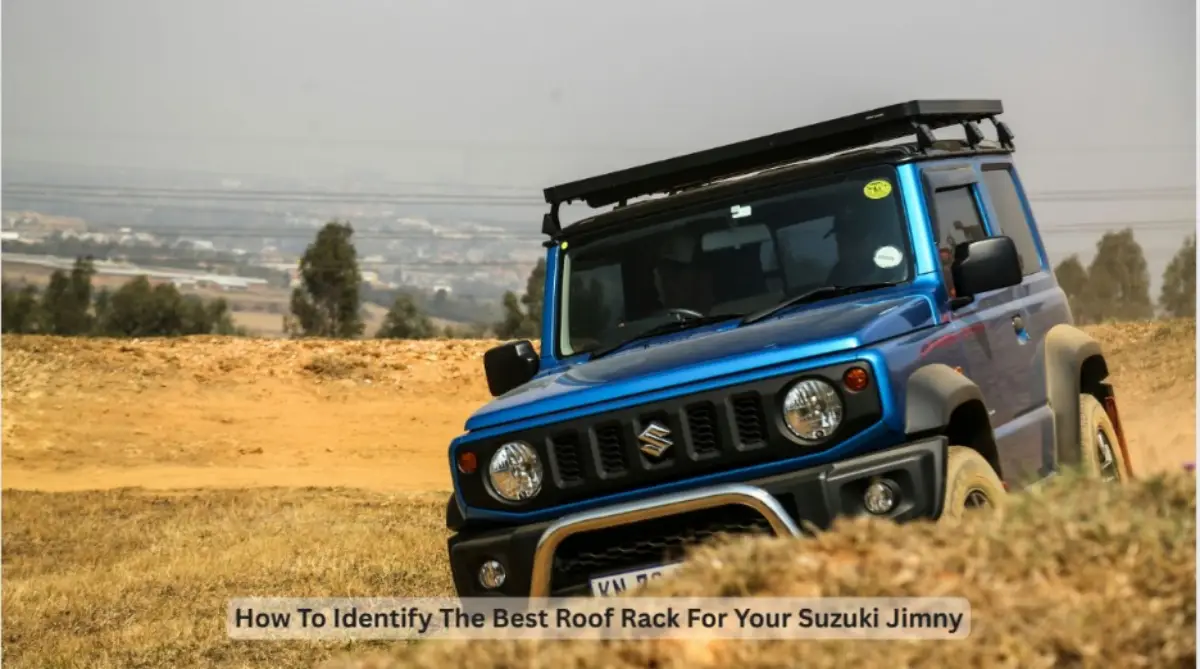 A blue Suzuki Jimny equipped with a roof rack drives on a dirt track, demonstrating off-road capability with added storage capacity.