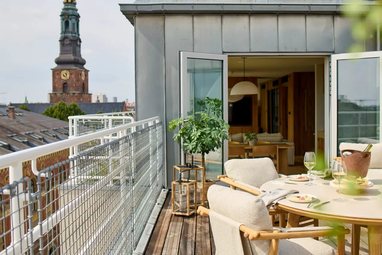 Balcony view from 1 Hotel Copenhagen suite with outdoor dining and city skyline