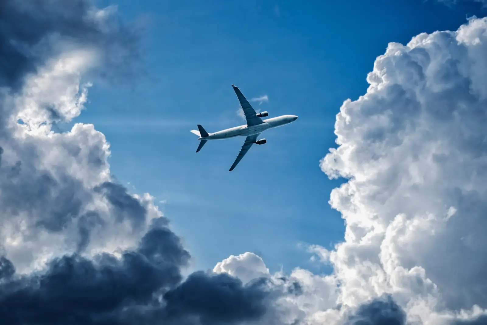 Airplane flying through dramatic clouds, illustrating turbulence risk