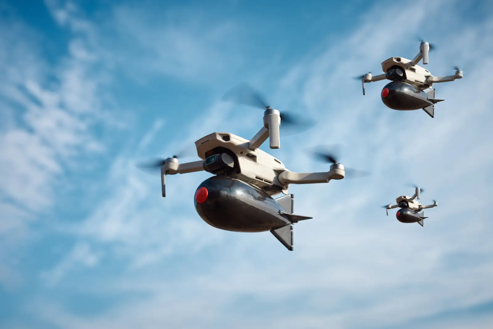 Armed drones flying in formation against a blue sky.