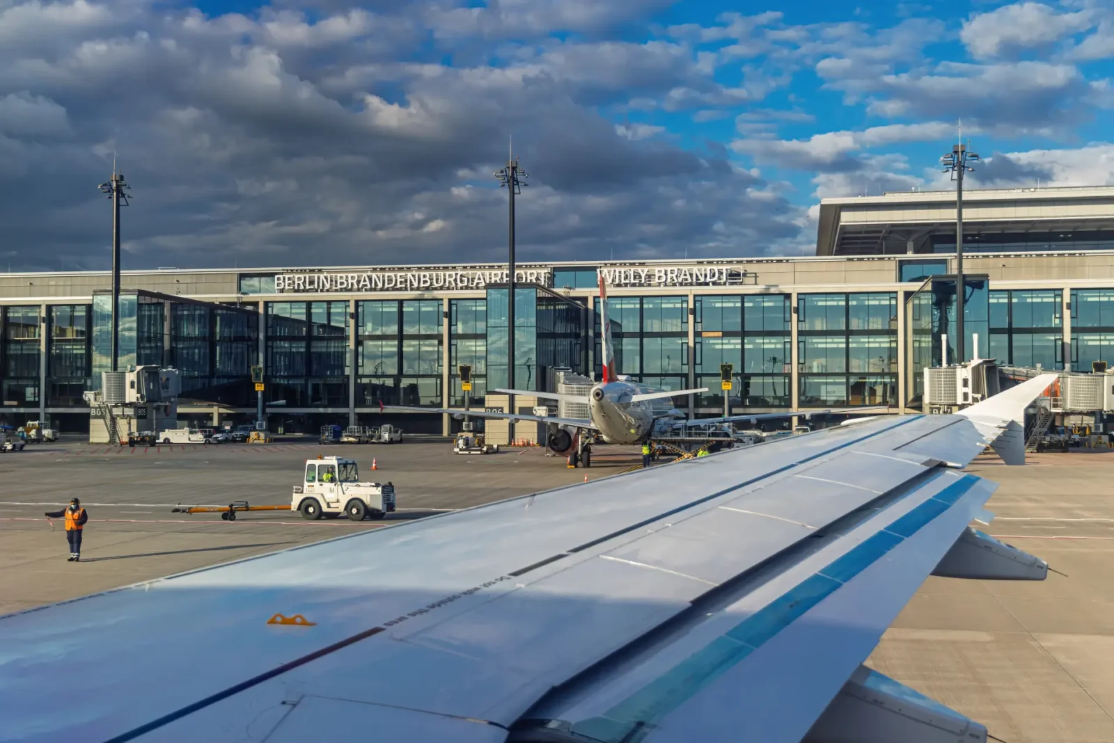 Berlin Brandenburg Airport terminal with aircraft on tarmac seen from airplane window