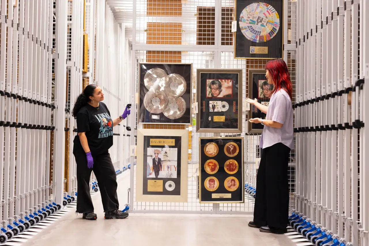 Get Up Close And Personal With David Bowie’s Legacy At London’s Victoria &Amp; Albert Museum 3 Two visitors view David Bowie’s framed awards and memorabilia in the archive storage at the V&A’s David Bowie Centre.