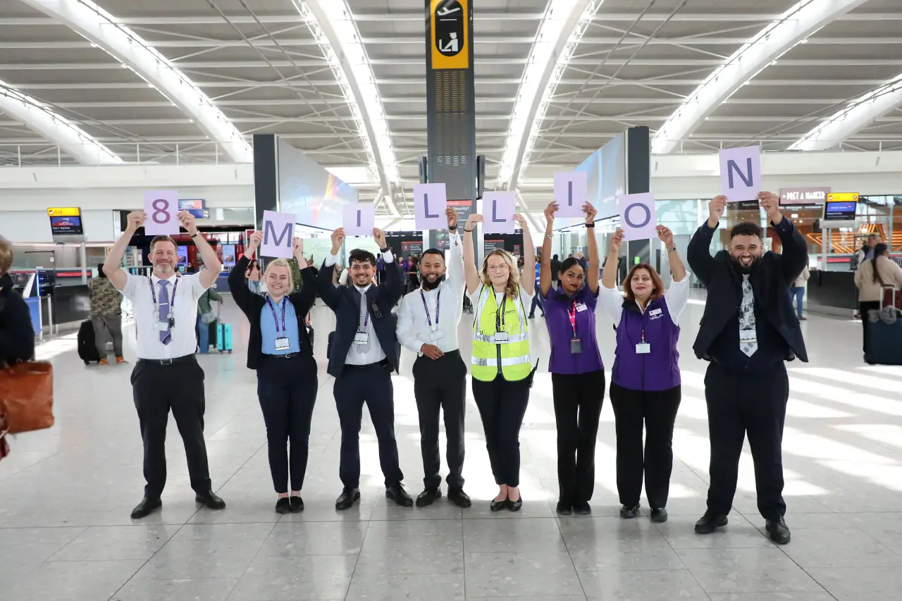 Europe’s Busiest Hub: Heathrow Surpasses 8 Million Travelers In One Month 2 Heathrow Airport staff celebrate milestone of 8 million passengers in one month, holding signs spelling “8 MILLION” inside the terminal.