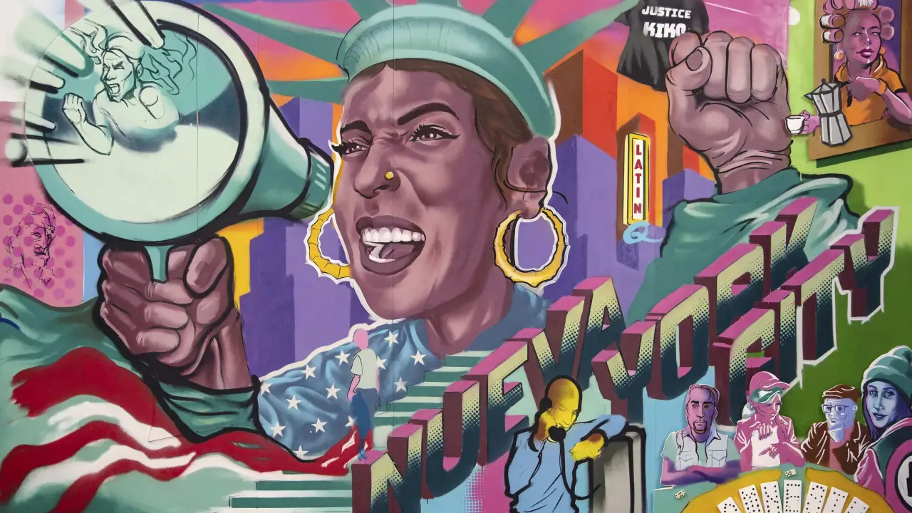 Colorful mural featuring a Latina figure in a Statue of Liberty crown shouting through a megaphone, with bold text reading “Nueva York City.”