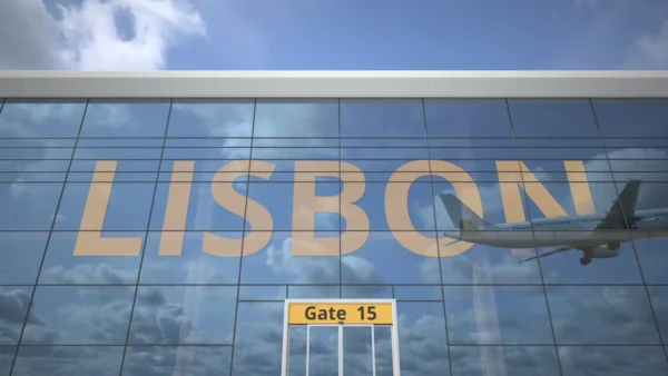 Lisbon airport terminal glass facade with airplane reflection and Gate 15 sign