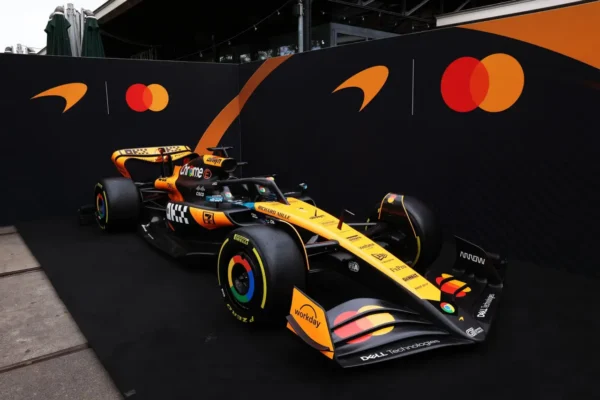 Home 7 McLaren Formula 1 car in papaya and black livery displayed with Mastercard branding as part of the 2026 team naming partnership announcement.