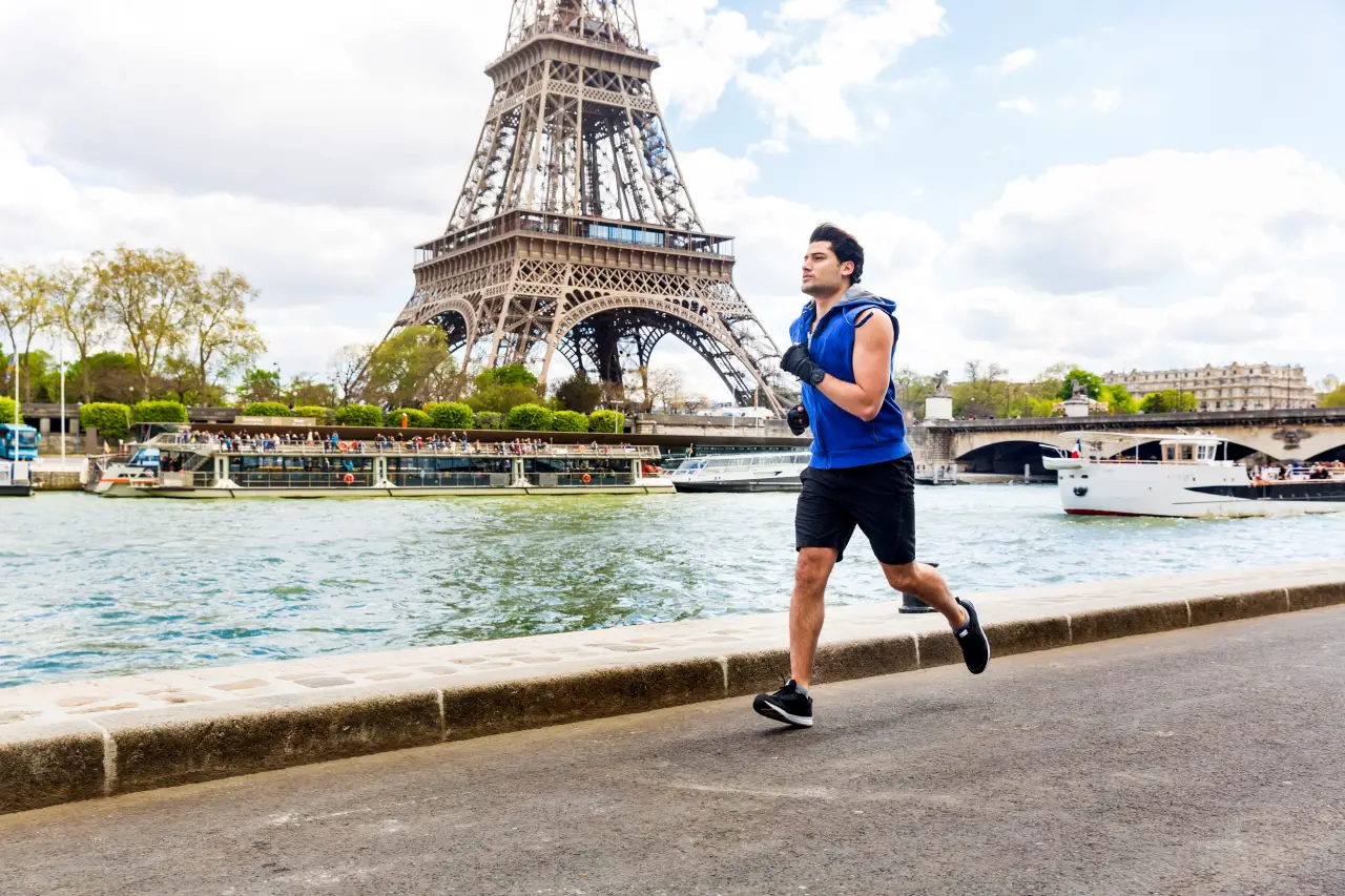 Paris Ranked World’s Top Sports City In 2025 Report 2 Man jogging along the Seine River near the Eiffel Tower in Paris.