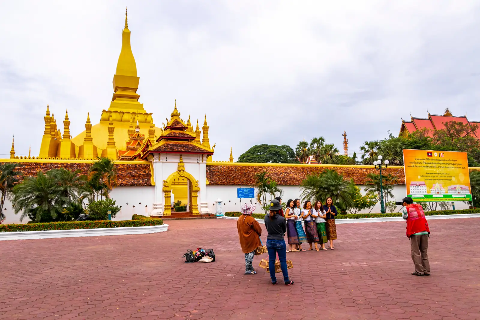 Tourists pose for photos at Pha That Luang, the iconic golden Buddhist stupa in Vientiane, Laos.