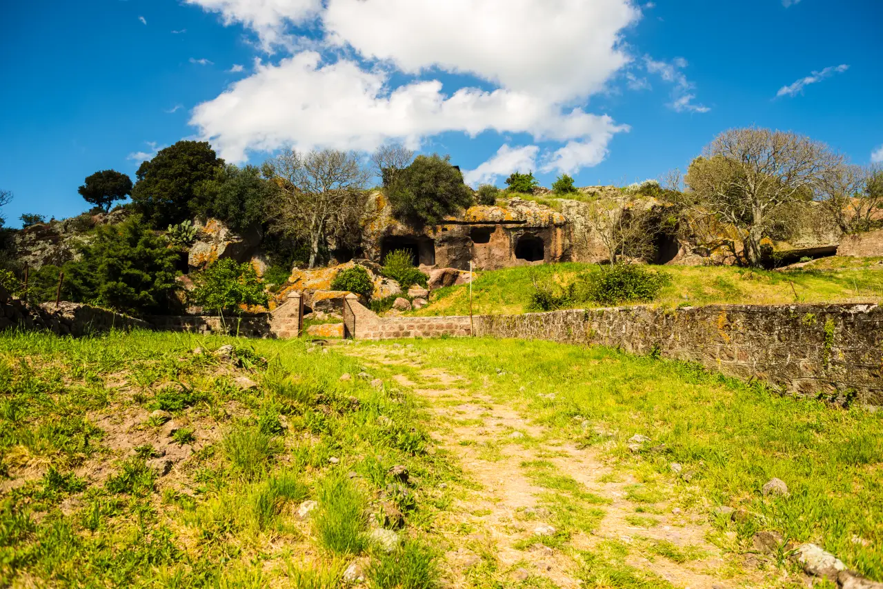 Sardinia’s “Fairy Houses” Added To Unesco World Heritage List 2 Sardinian necropolis carved into rock surrounded by green landscape in spring