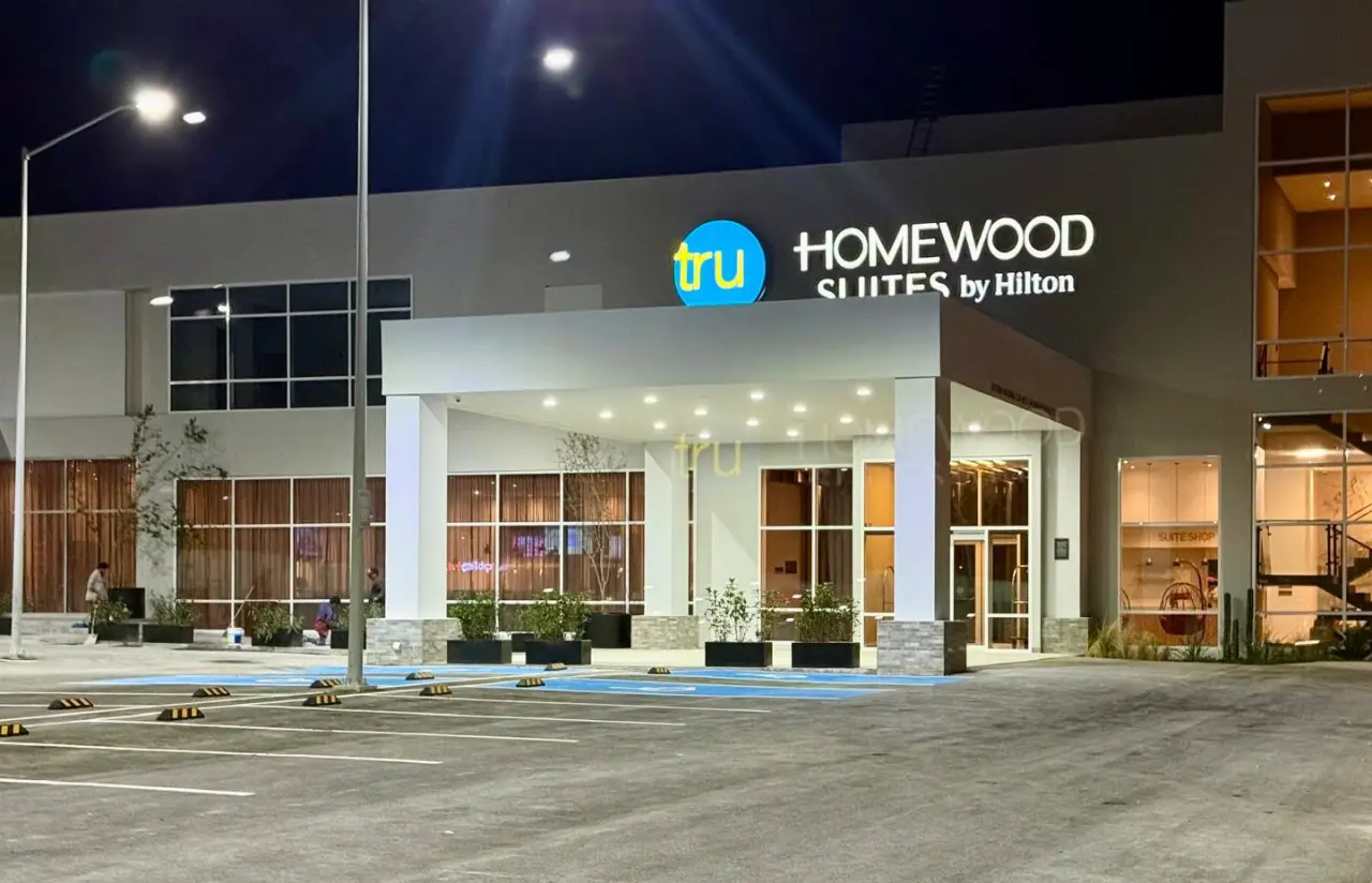 Facade of Tru by Hilton and Homewood Suites by Hilton Saltillo at night with illuminated signs