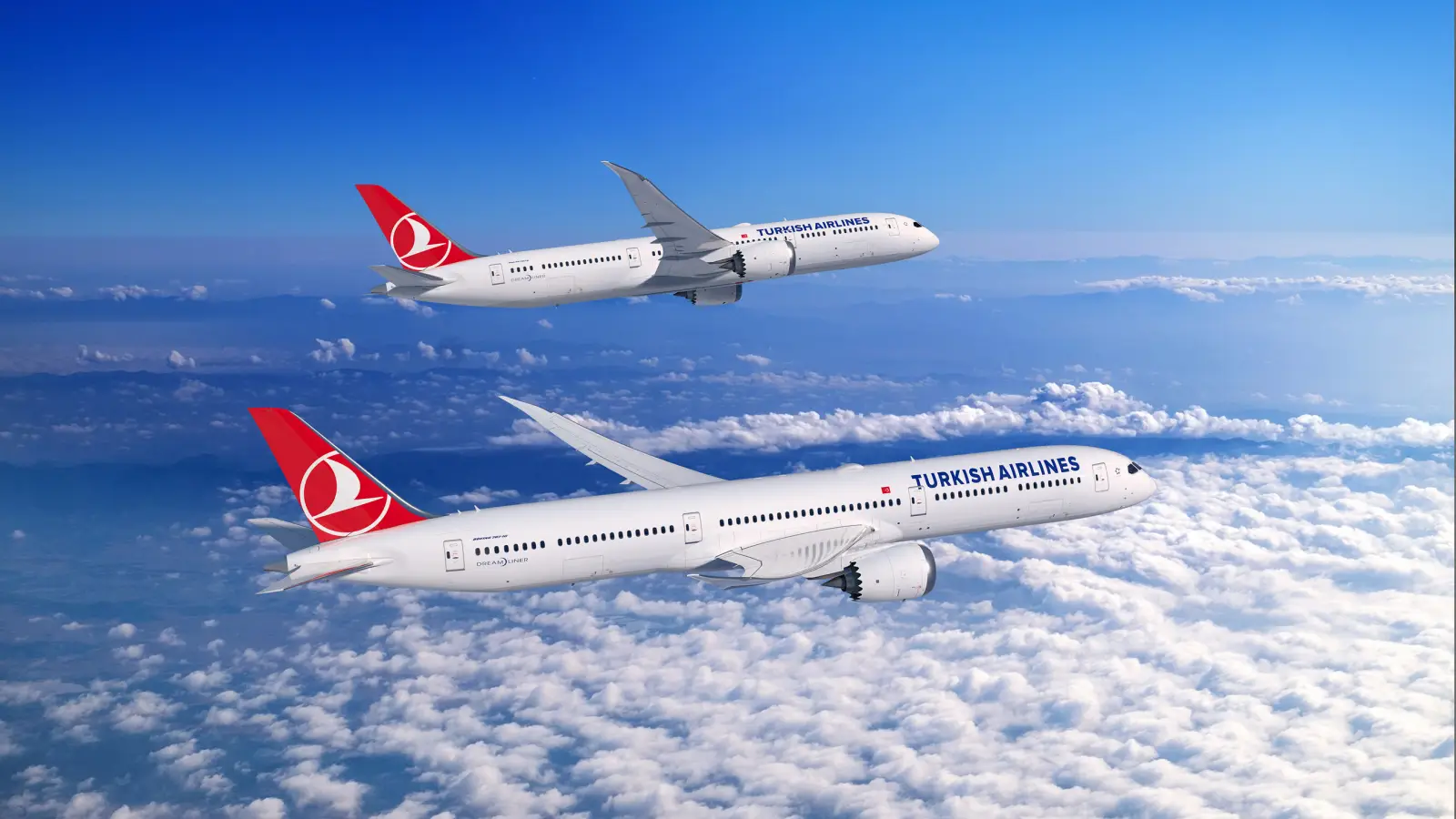 Two Turkish Airlines Boeing 787 Dreamliners flying above the clouds with clear skies in the background.