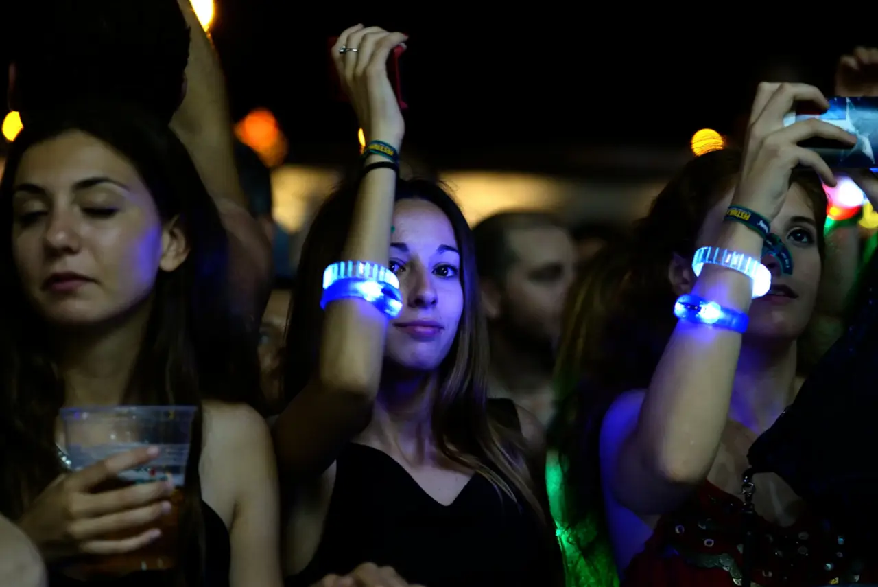 Crowd enjoying nightlife at Festival de les Arts in Valencia, Spain, with glowing wristbands and drinks