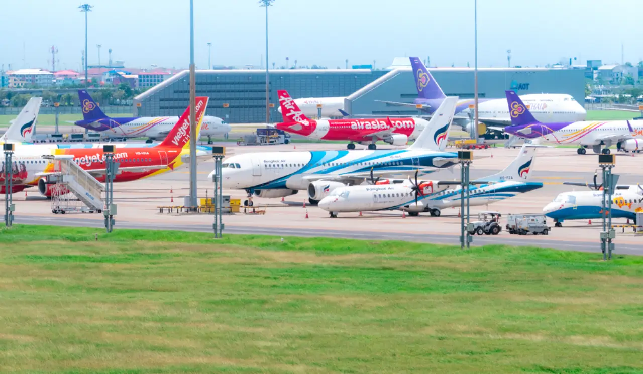 Vietjet Thailand Expands Fleets, Faces Pilot Shortage 10 Several Thai airline aircraft, including Vietjet and Bangkok Airways, parked at a busy airport terminal in Thailand.