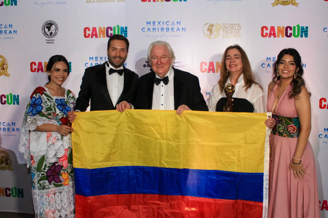 Award winners at World Travel Awards 2025 Latin America in Cancún, holding Colombia’s flag
