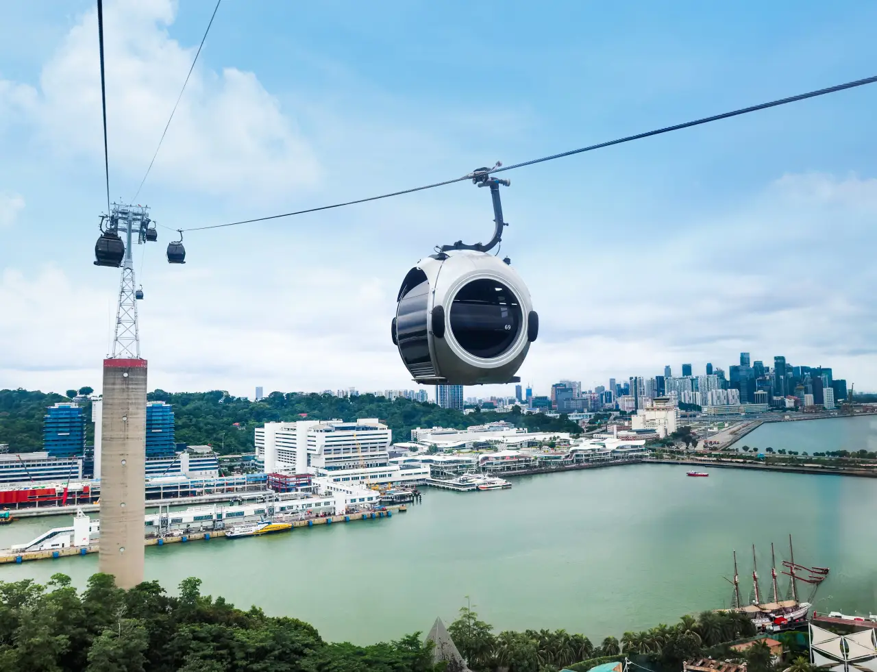 Singapore Cable Car Expands The World’s First SkyOrb Cabin Fleet 37 SkyOrb cable car cabin gliding above Singapore’s harbor with city skyline in the background.