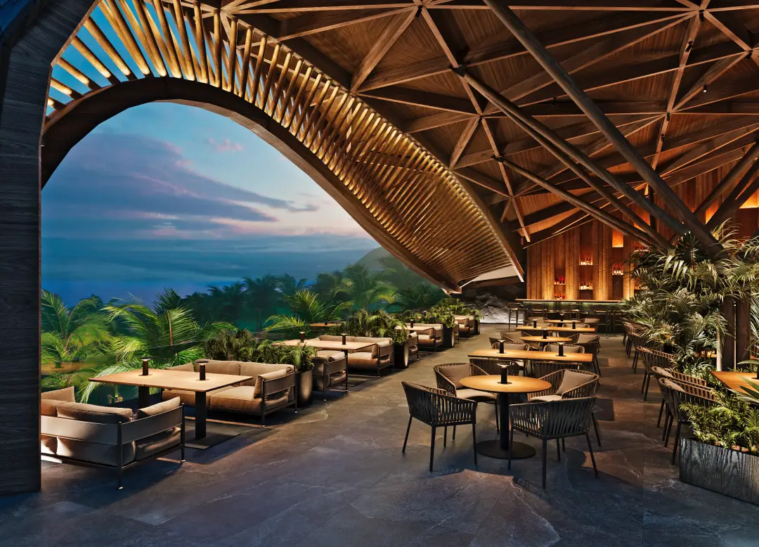 The Lux Collective Brings Its Conscious Salt Brand To Bali’s Unspoilt Coast 3 Open-air restaurant with wooden architecture overlooking tropical palm trees and ocean views at sunset.