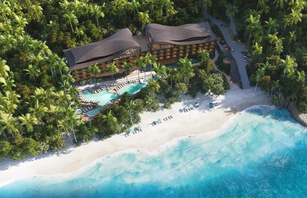 The Lux Collective Brings Its Conscious SALT Brand to Bali’s Unspoilt Coast 21 Aerial view of a beachfront eco-luxury resort surrounded by tropical palm trees and turquoise ocean.