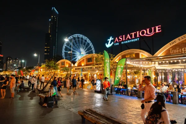 Home 10 People walking and dining at Asiatique The Riverfront night market in Bangkok.