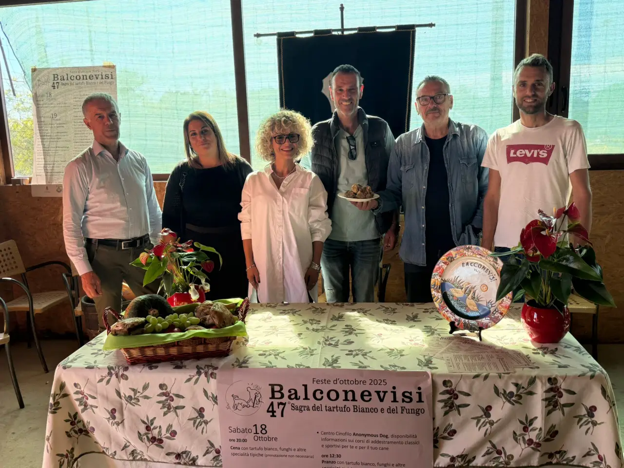 Group of organizers posing at the presentation table for Balconevisi’s 47th White Truffle and Mushroom Festival in Tuscany.